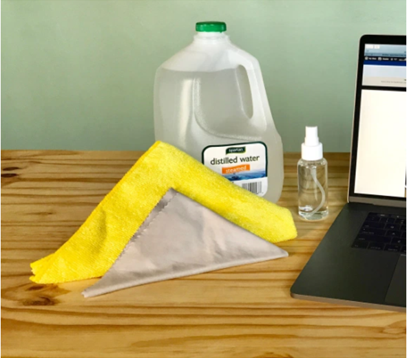 distilled water, spray bottle, and dry clothes for cleaning Mac trackpad